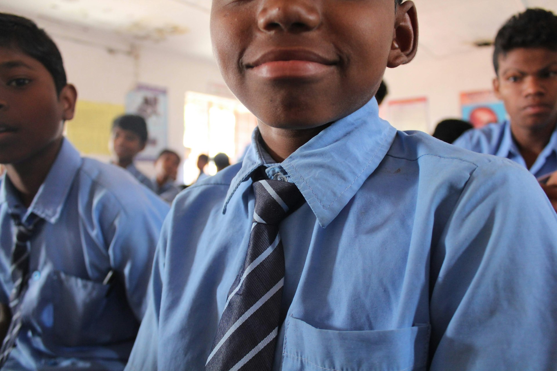 a group of young boys wearing blue shirts and ties